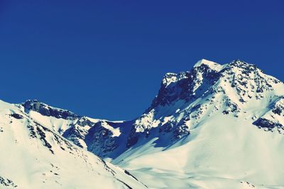 Scenic view of snowcapped mountains against clear blue sky