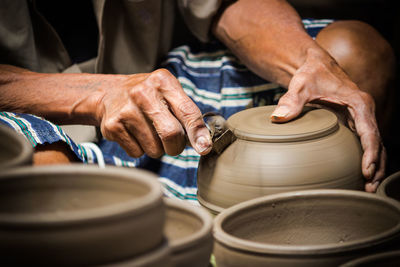 Midsection of man shaping bowl in workshop