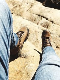 Low section of man standing on sand