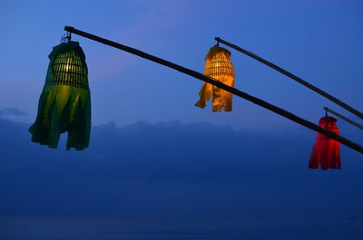 Low angle view of illuminated lighting equipment against clear sky