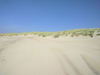 Scenic view of desert against clear blue sky