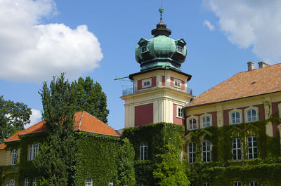 Low angle view of trees and buildings against sky