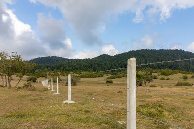 Wooden fence on field against sky