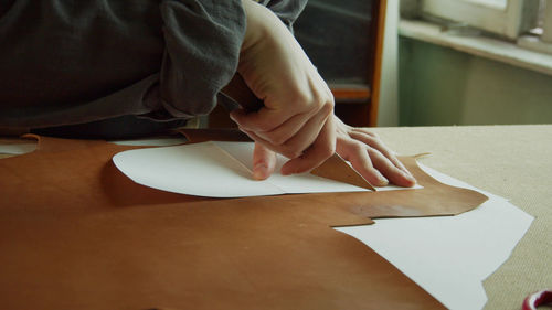 High angle view of woman hand holding paper on table