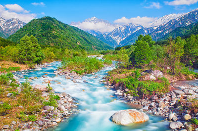 Scenic view of lake amidst mountains against sky