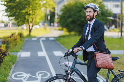 Portrait of young man riding bicycle on road