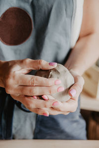 Midsection of woman at pottery workshop