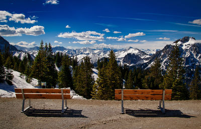 Bench in park against mountains during winter
