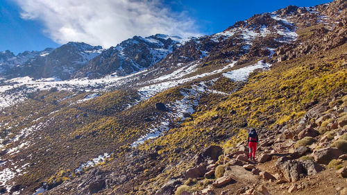 Scenic view of snowcapped high mountains and a lone traveler