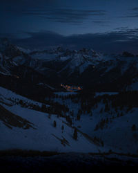 Aerial view of snowcapped mountains against sky at night