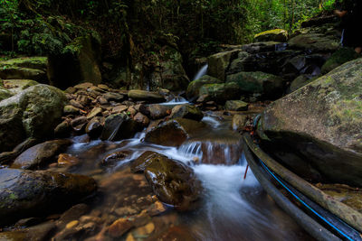 Stream flowing through rocks in forest