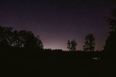 Silhouette trees against sky at night