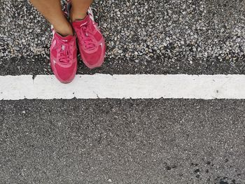 Low section of woman standing on road