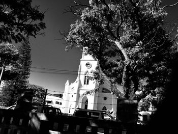 Low angle view of trees and buildings against sky