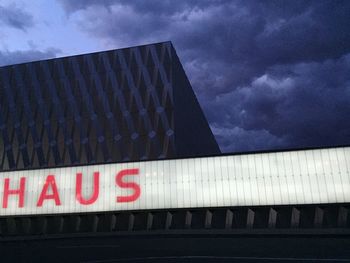 Low angle view of modern building against cloudy sky