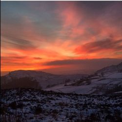 Snow covered landscape at sunset