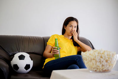 Thoughtful woman watching tv at home