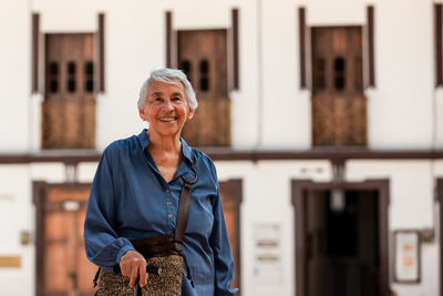 Portrait of young woman standing in city