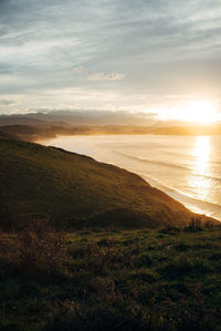 Scenic view of landscape against sky during sunset at the beach 