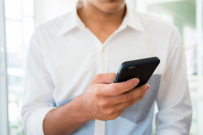 Midsection of man using mobile phone