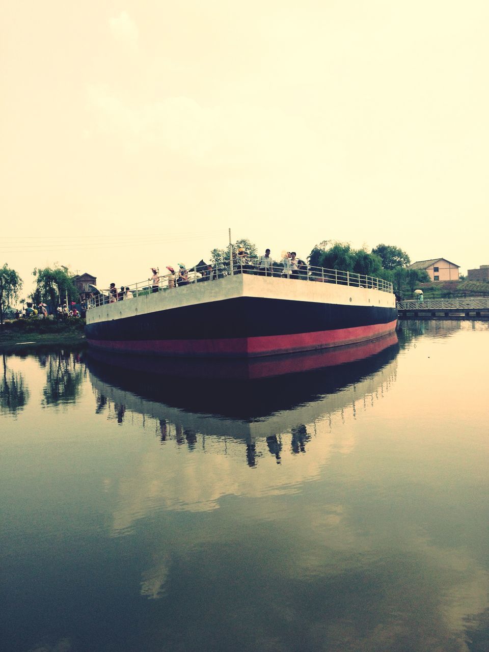 water, waterfront, nautical vessel, transportation, reflection, boat, built structure, sky, architecture, mode of transport, river, travel, clear sky, moored, lake, tree, tourism, travel destinations, nature, outdoors