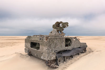 Army tank with bullet holes in the sand