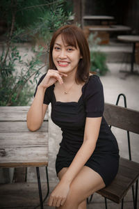 Portrait of young woman sitting at park