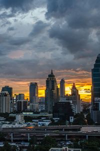 Buildings in city against cloudy sky