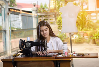 Girl using sewing machine in workshop