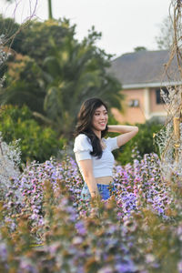 Young woman standing on flowering plants