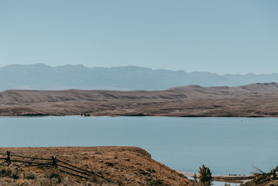 Scenic view of lake against clear blue sky