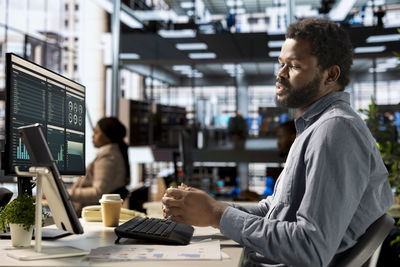 Side view of man using laptop while sitting in cafe