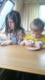 Girl and son on table