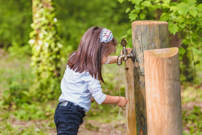 Side view of a girl on wooden fence