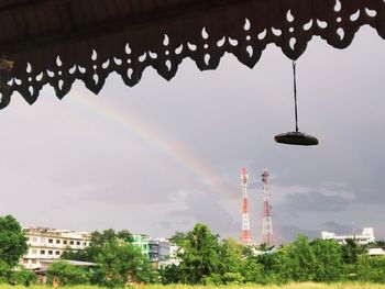 Low angle view of rainbow over buildings against sky