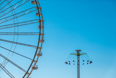 Low angle view of ferris wheel against clear blue sky