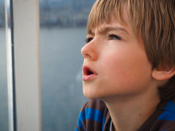 Close-up of boy looking up outdoors