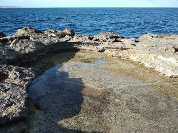 Scenic view of rocks on beach against sky