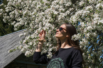 Beautiful woman standing by flower plants