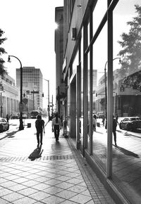 People walking on footpath in city