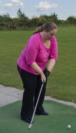 Full length of woman playing golf on field