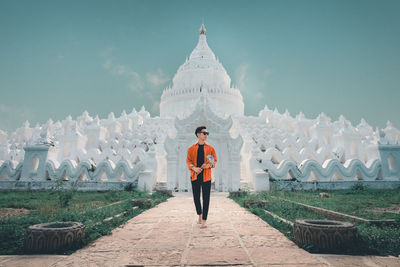 Portrait of man standing on temple against sky