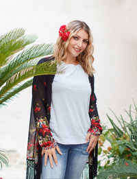 Portrait of smiling woman standing against wall