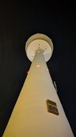 Low angle view of illuminated clock tower against sky at night