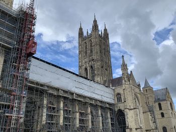 Low angle view of buildings against cloudy sky