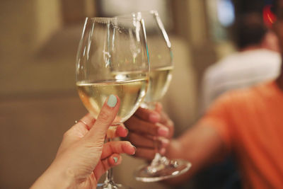 Midsection of woman holding glass of wine