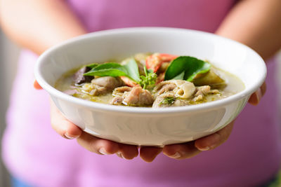 Close-up of hand holding soup in bowl