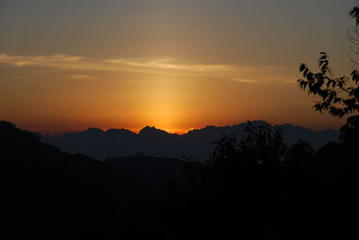 Scenic view of silhouette mountains against orange sky