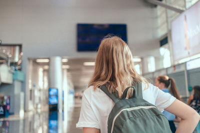 Rear view of woman standing at airport