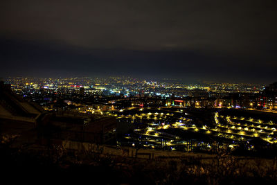 High angle view of illuminated buildings against sky at night